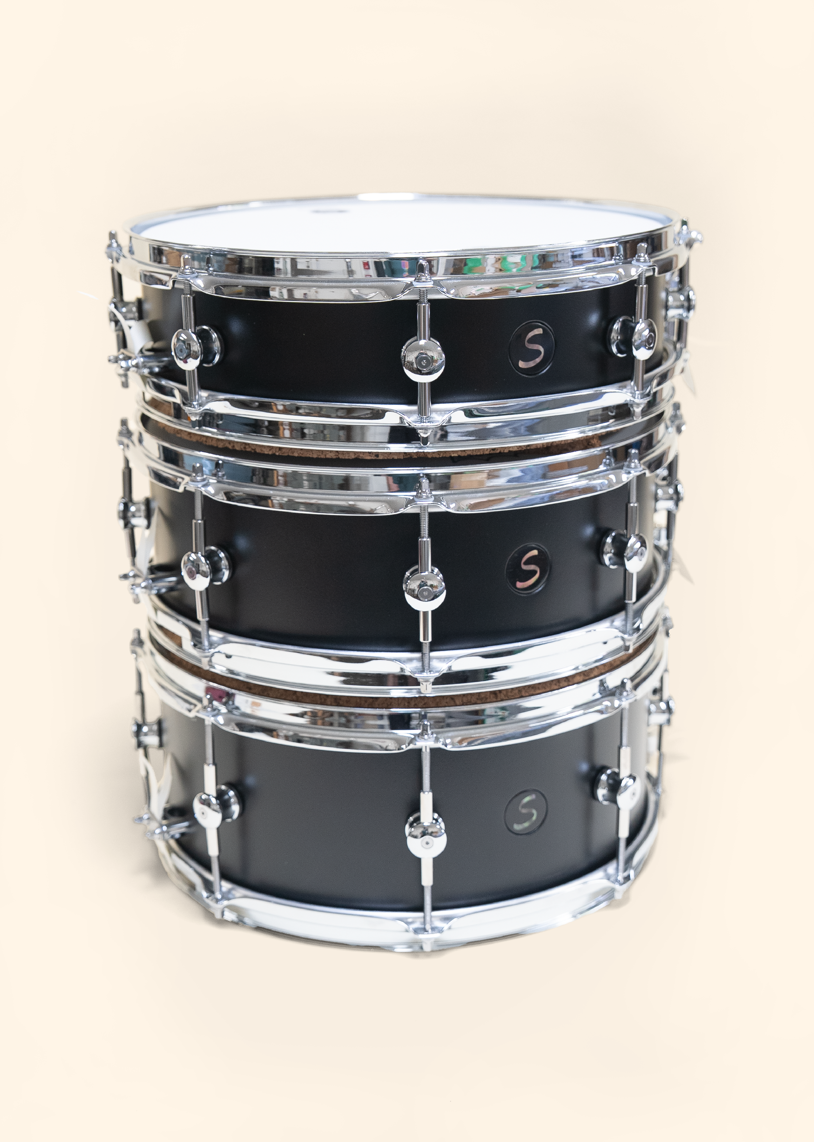 Black painted Poplar drums with clear matte finish. Ebony badges with black pearl inlay.  Three different sizes with two hoops options.